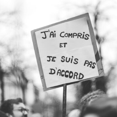 Photo by ev - Lina Hadid a person holding a sign that says i'm comptis et je sui